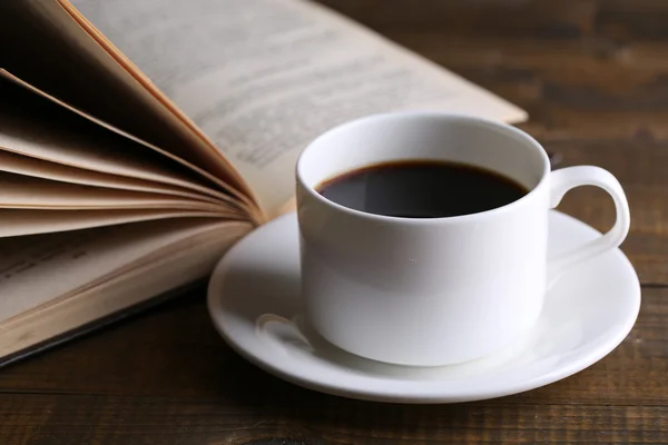 Taza de café caliente con libro sobre fondo de madera —  Fotos de Stock