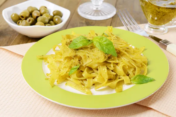 Deliciosa pasta con pesto en plato en primer plano de la mesa — Foto de Stock