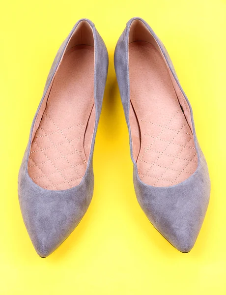 Krásné šedé ženské boty, na žlutém podkladu — Stock fotografie