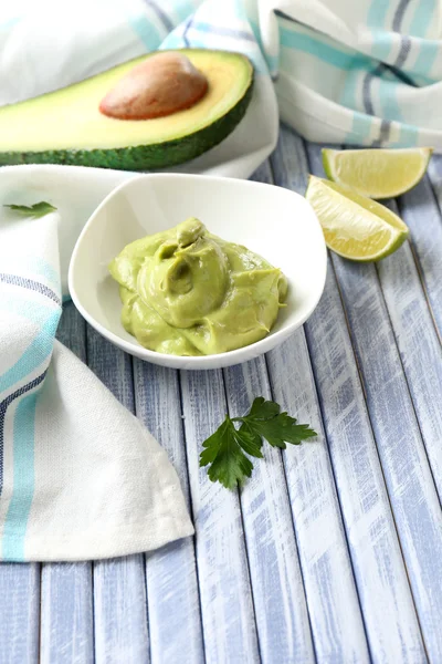 Guacamole fresco na tigela na mesa de madeira — Fotografia de Stock