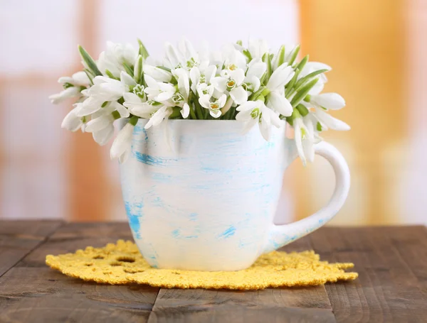 Beaux gouttes de neige dans un vase, sur une table en bois sur fond lumineux — Photo