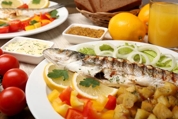 Delicious grilled fish on plate on table close-up — Stock Photo, Image