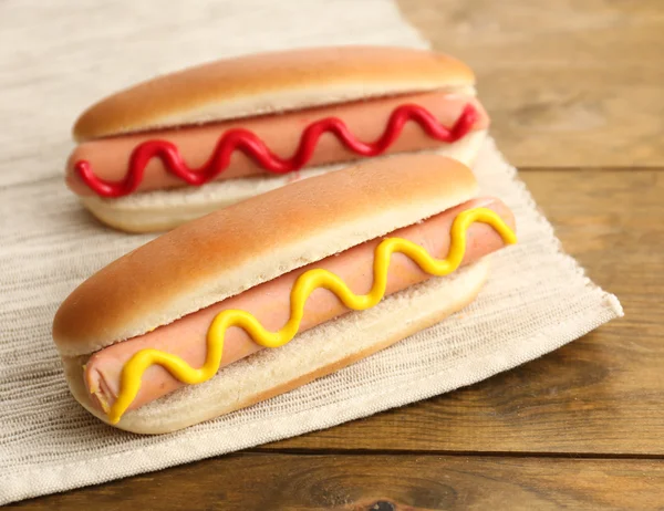 Tasty hot dogs on wooden table — Stock Photo, Image