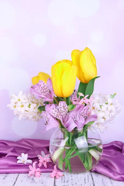 Flores em vaso na mesa em fundo brilhante — Fotografia de Stock