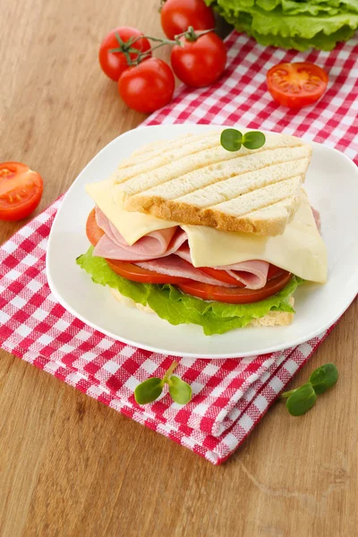 Leckeres Sandwich mit Schinken auf Holztisch — Stockfoto