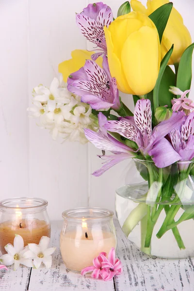 鲜花插在花瓶里插着蜡烛上木制背景表格 — 图库照片