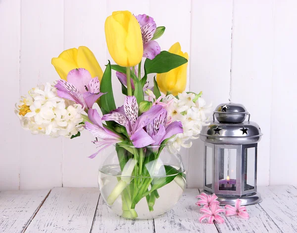 Fiori in vaso con lanterna decorativa sul tavolo su sfondo di legno — Foto Stock