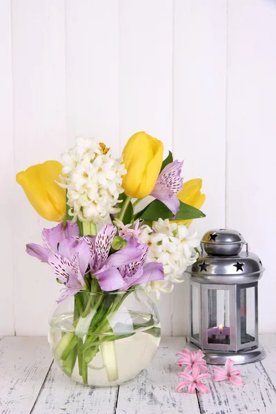 Bloemen in vaas met decoratieve lantaarn op tafel op houten achtergrond — Stockfoto