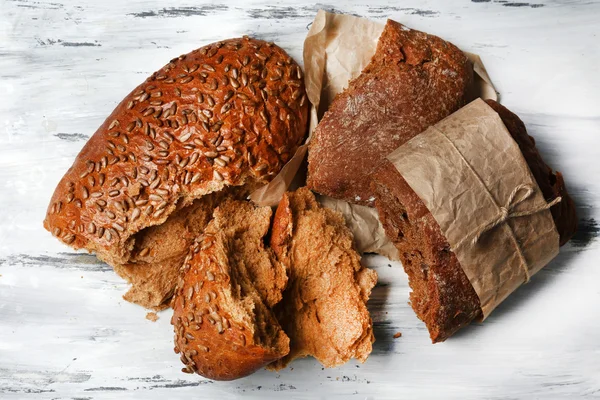 Breaking bread on wooden table — Stock Photo, Image