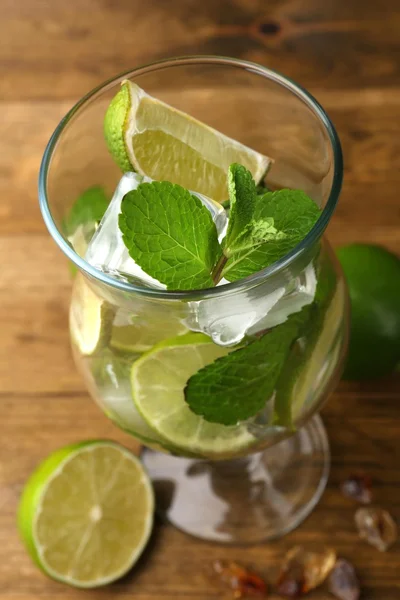 Ingredients for lemonade in glass, on wooden table — Stock Photo, Image