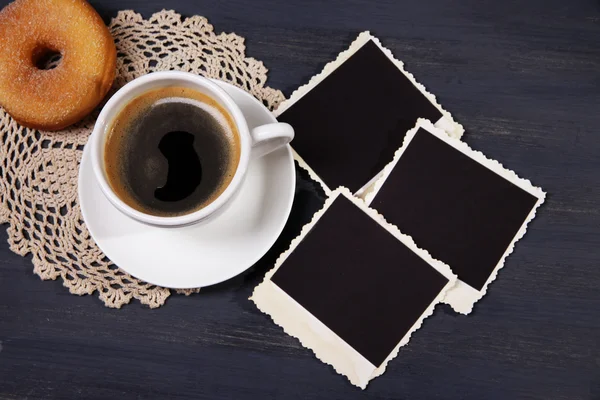 Taza de café, rosquilla y viejas fotos en blanco, sobre fondo de madera — Foto de Stock