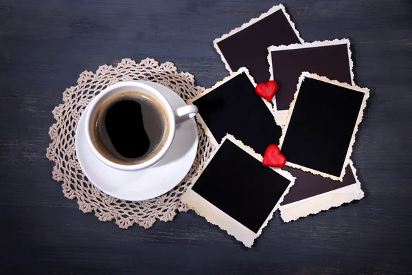 Sammansättning med kaffekoppen, dekorativa hjärtan och gamla tomma bilder, på trä bakgrund — Stockfoto