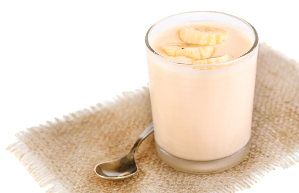 Iogurte delicioso com sabor a frutas em vidro em guardanapo, isolado em branco — Fotografia de Stock