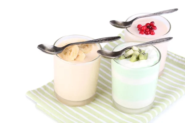 Heerlijke yoghurt met fruit smaken in glazen op servet, geïsoleerd op wit — Stockfoto