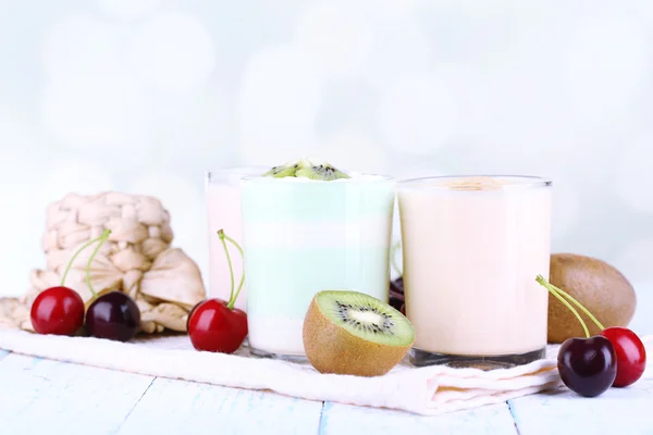 Pyszny jogurt z owocami smakuje w okularach i świeże owoce w serwetkę, na jasnym tle — Zdjęcie stockowe