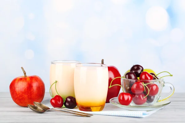 Pyszny jogurt z owocami smakuje w okularach i świeże owoce w serwetkę, na drewnianym stole kolor, na jasnym tle — Zdjęcie stockowe