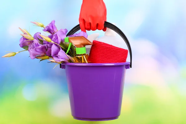 Dona de casa segurando balde com equipamento de limpeza em fundo de cor. Foto conceitual de limpeza de primavera . — Fotografia de Stock