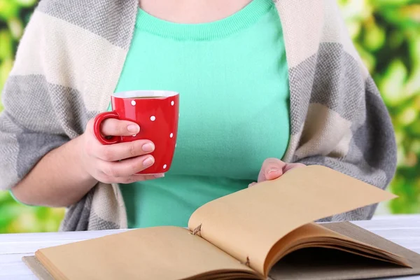 Kobieta czyta książki i picia kawy lub herbaty, szczelnie-do góry — Zdjęcie stockowe