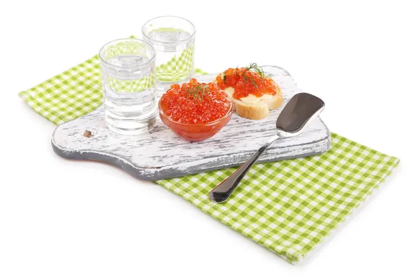 Red caviar in bowl and vodka on wooden board , on napkin isolated on white — Stock Photo, Image