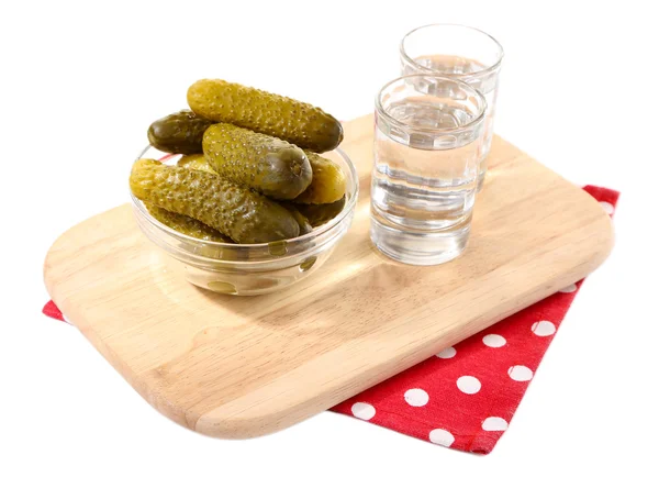 Glasögon av vodka och saltad gurka på träplatta isolerad på vit — Stockfoto