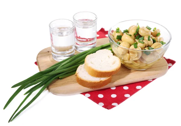Copo de vodka e cogumelos marinados em tábua de madeira isolada em branco — Fotografia de Stock
