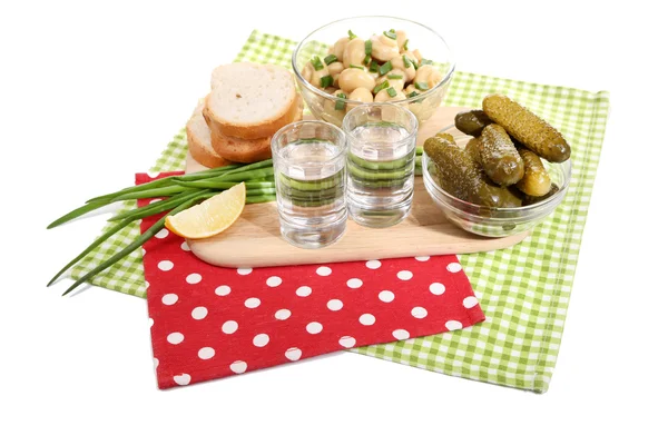 Composição com vidro de vodka e cogumelos marinados, pepinos em tábua de madeira isolada em branco — Fotografia de Stock