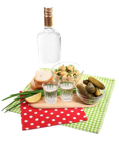 Sammansättning med en flaska vodka och marinerade champinjoner, gurkor på träplatta isolerad på vit — Stockfoto