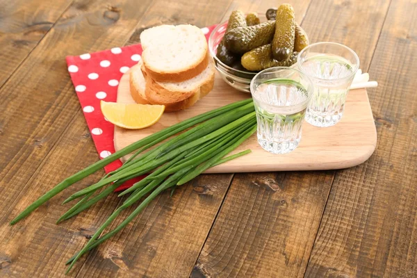 Sammansättning med glasögon av vodka och marinerad gurka på trä bakgrund — Stockfoto