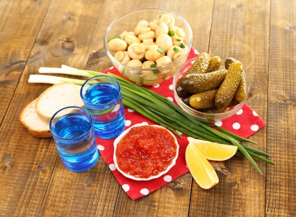 Composition avec verre de vodka et champignons marinés, concombres sur fond bois — Photo