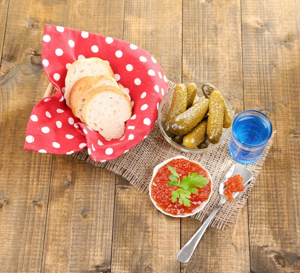 Samenstelling met glas wodka en gemarineerde paddestoelen, komkommers op houten achtergrond — Stockfoto