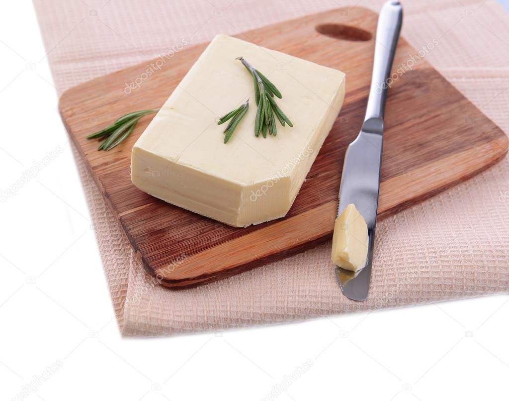 Tasty butter on wooden cutting board, isolated on white 