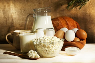 arka plan çuval bezi üzerinde ahşap masa üstünde lezzetli süt ürünleri