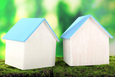 Small wooden house on grass on bright background clipart