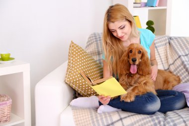 cocker spaniel odasındaki kanepenin üzerine ile güzel genç kadın