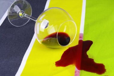 Overturned glass of wine on table close-up clipart