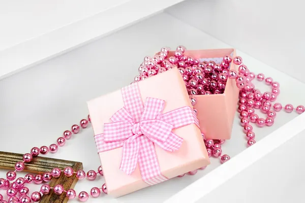 Gift box and beads in open desk drawer close up — Stock Photo, Image