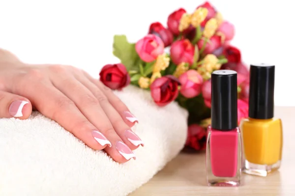 아름 다운 여 자가 손을 프랑스어 매니큐어와 흰색 바탕에 테이블에 꽃 — 스톡 사진