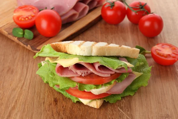 Lekkere sandwich met ham op houten tafel — Stockfoto