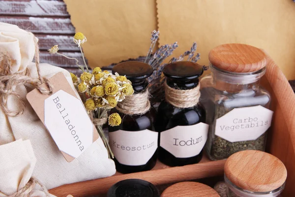 Historische oude apotheek flessen met label, laptop en roll, op een houten achtergrond kleur — Stockfoto