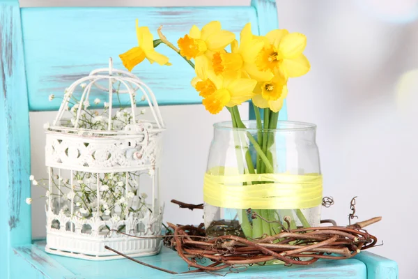 Beautiful spring flowers on blue old wooden chair — Stock Photo, Image