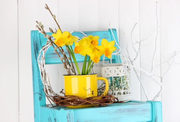 Beautiful spring flowers on blue old wooden chair — Stock Photo, Image