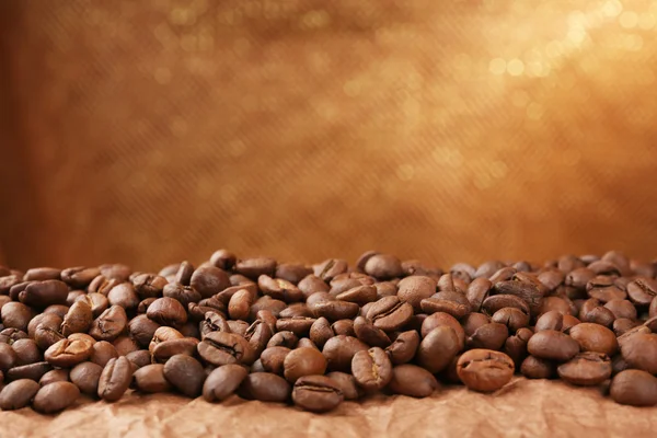 Grains de café sur la table sur fond brun — Photo