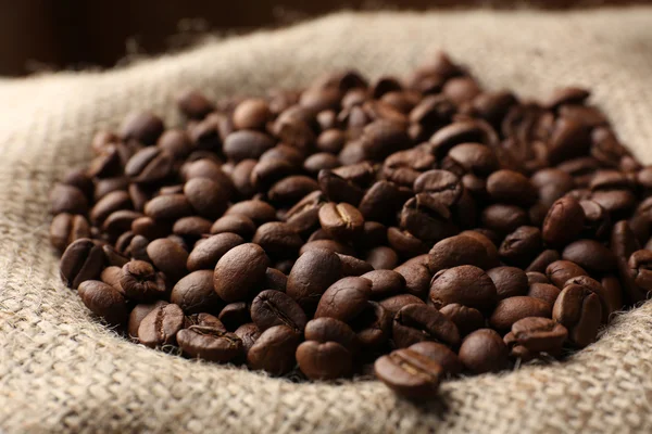 Coffee beans in sack on table close-up — Stock Photo, Image