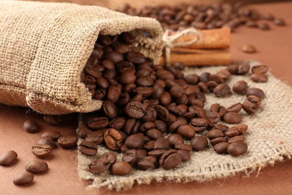 Grãos de café em saco na mesa close-up — Fotografia de Stock