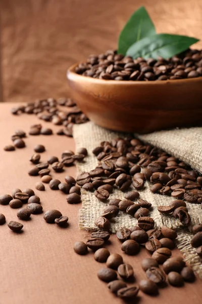 Chicchi di caffè sul tavolo su sfondo marrone — Foto Stock