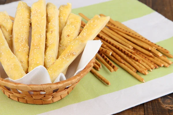 Bread sticks  in wicker basket on wooden background — Stock Photo, Image