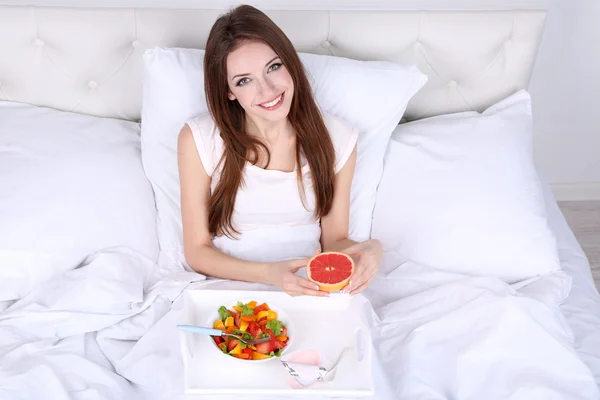 年轻漂亮的女人在床上与轻便的早餐 — 图库照片