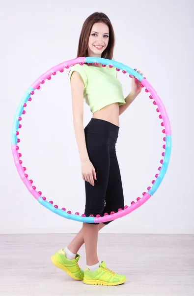 Mujer haciendo ejercicios con hula hoop en la habitación — Foto de Stock