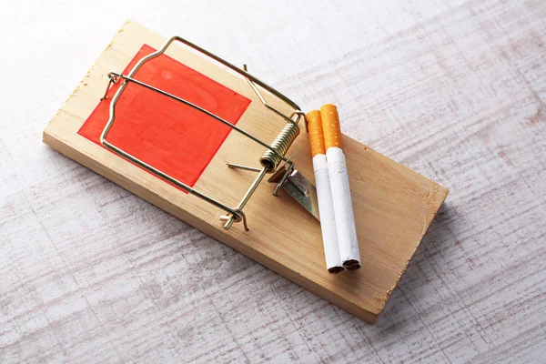 Pułapka na myszy z papierosów, na tle drewniane — Zdjęcie stockowe