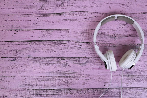 White headphones on wooden table close-up — Stock Photo, Image